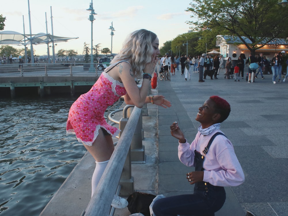 白いドレスシャツを着た男の横に立つピンクのドレスを着た女の子