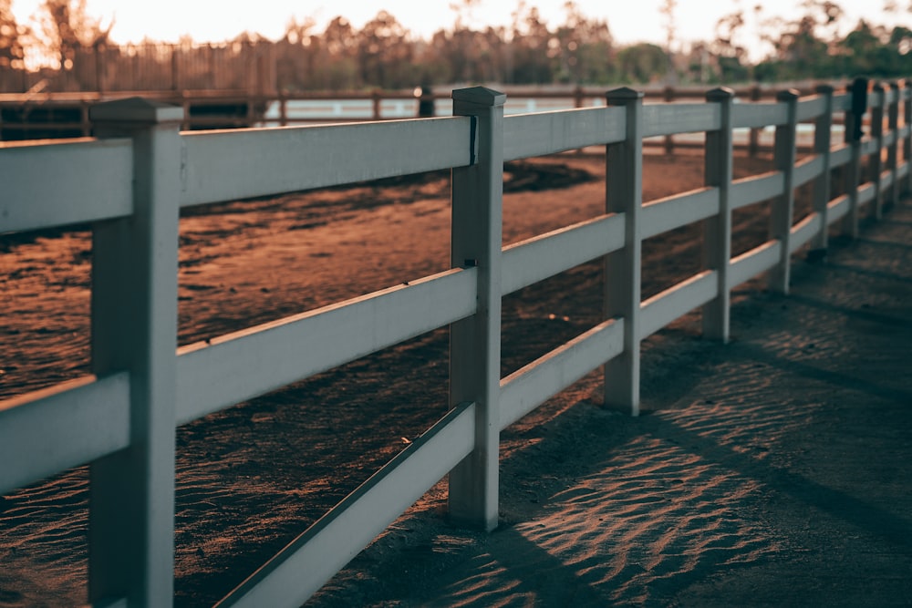 a close up of a fence on a dirt field