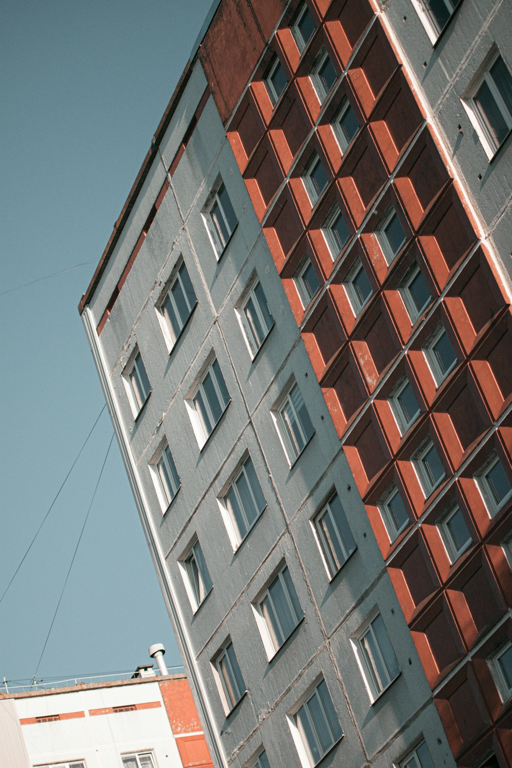 Edificio de hormigón marrón y blanco bajo el cielo azul durante el día