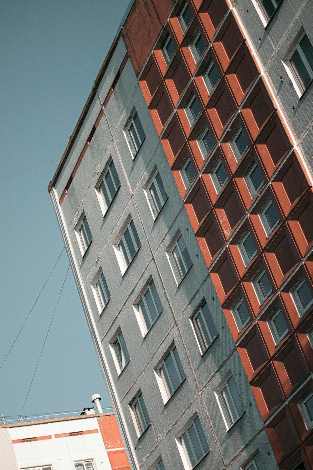 edifício de concreto marrom e branco sob o céu azul durante o dia