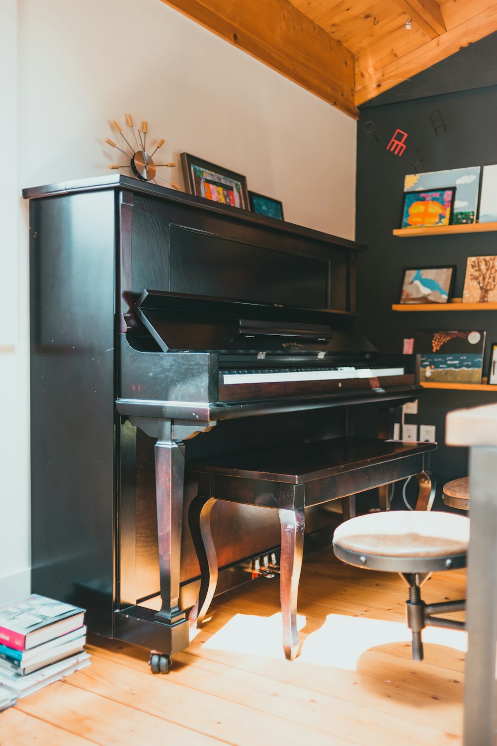 black upright piano near brown wooden shelf