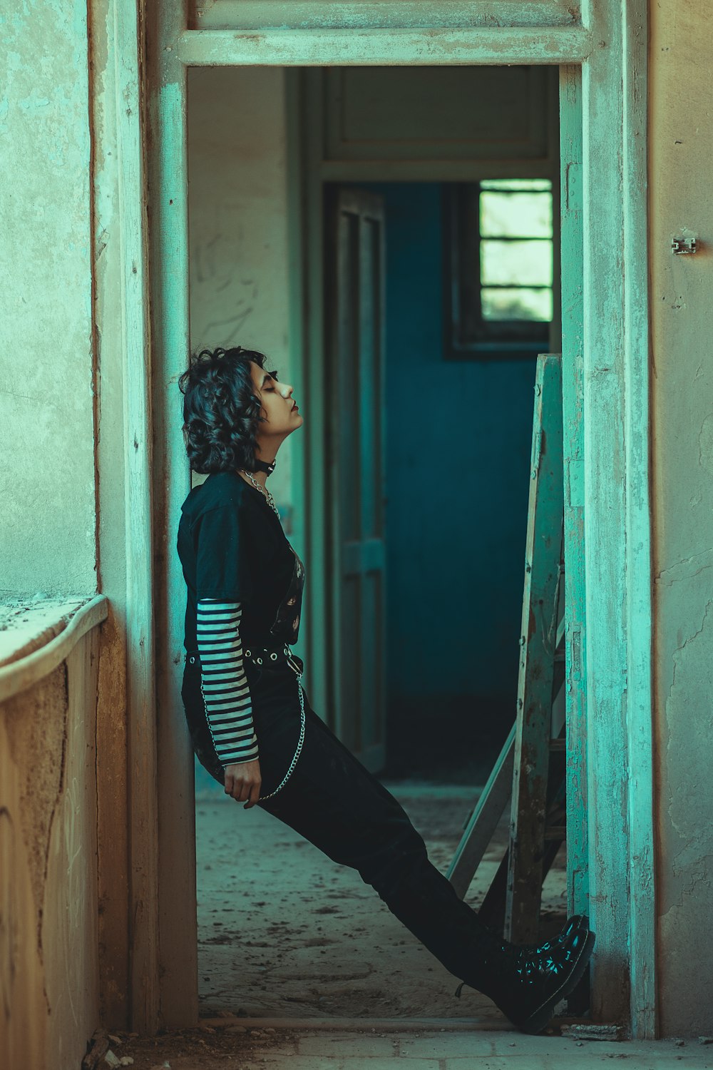 woman in black and white striped long sleeve shirt and black pants sitting on window