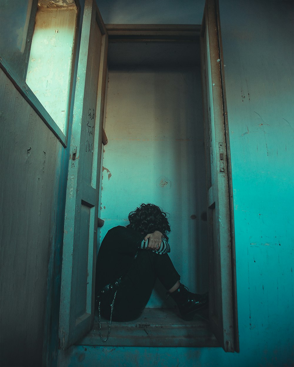 man in black jacket sitting on doorway