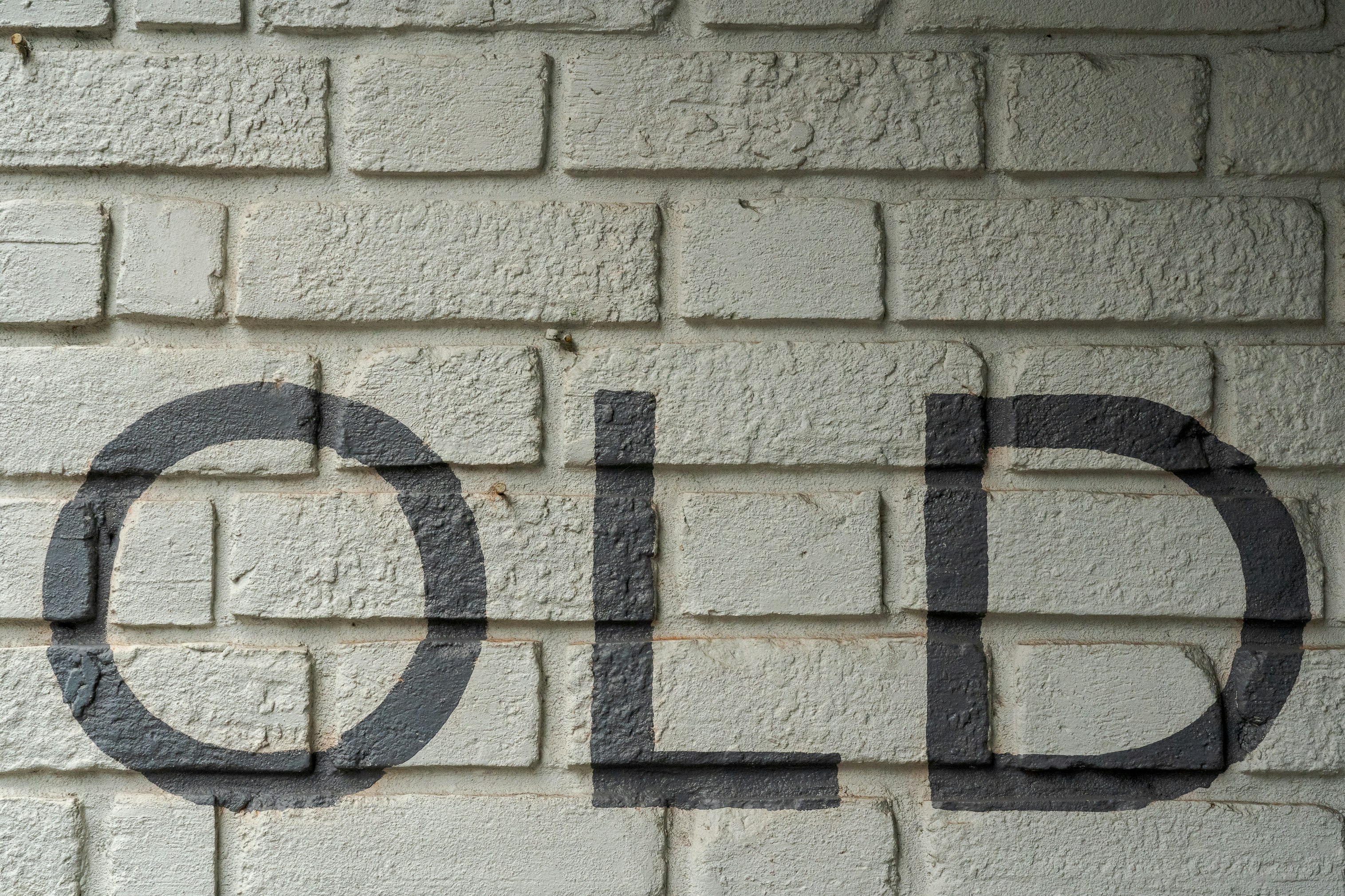 white brick wall with black metal fence