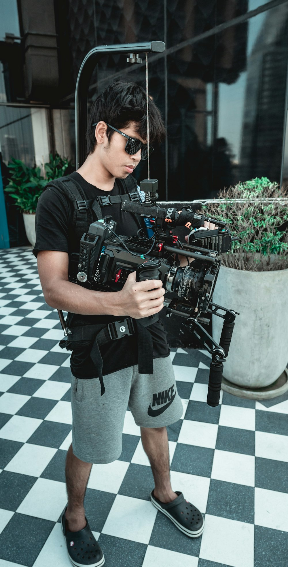 man in black crew neck t-shirt and black pants holding black dslr camera