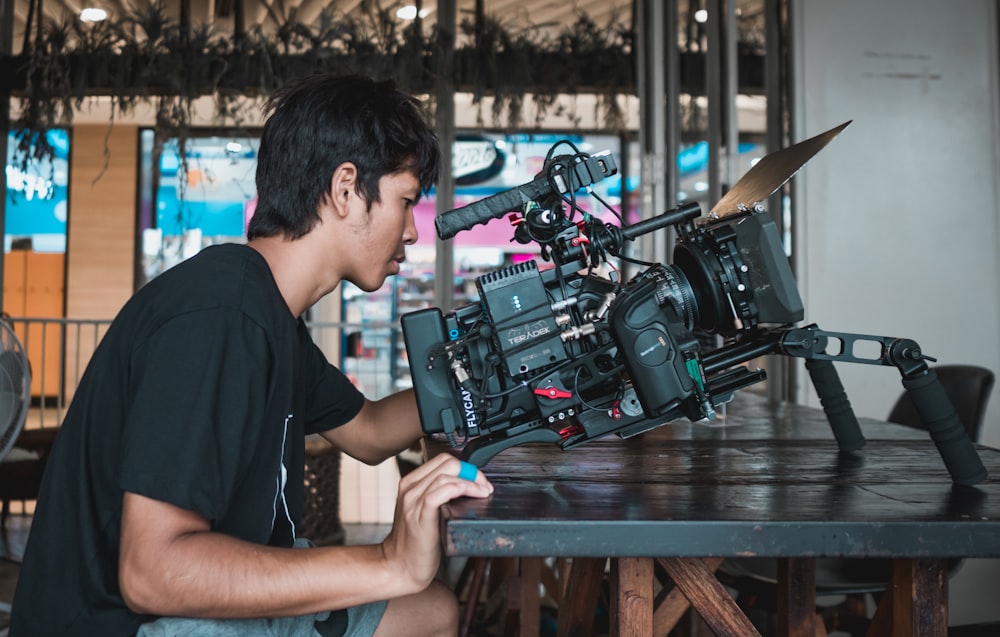 man in black crew neck t-shirt using black video camera