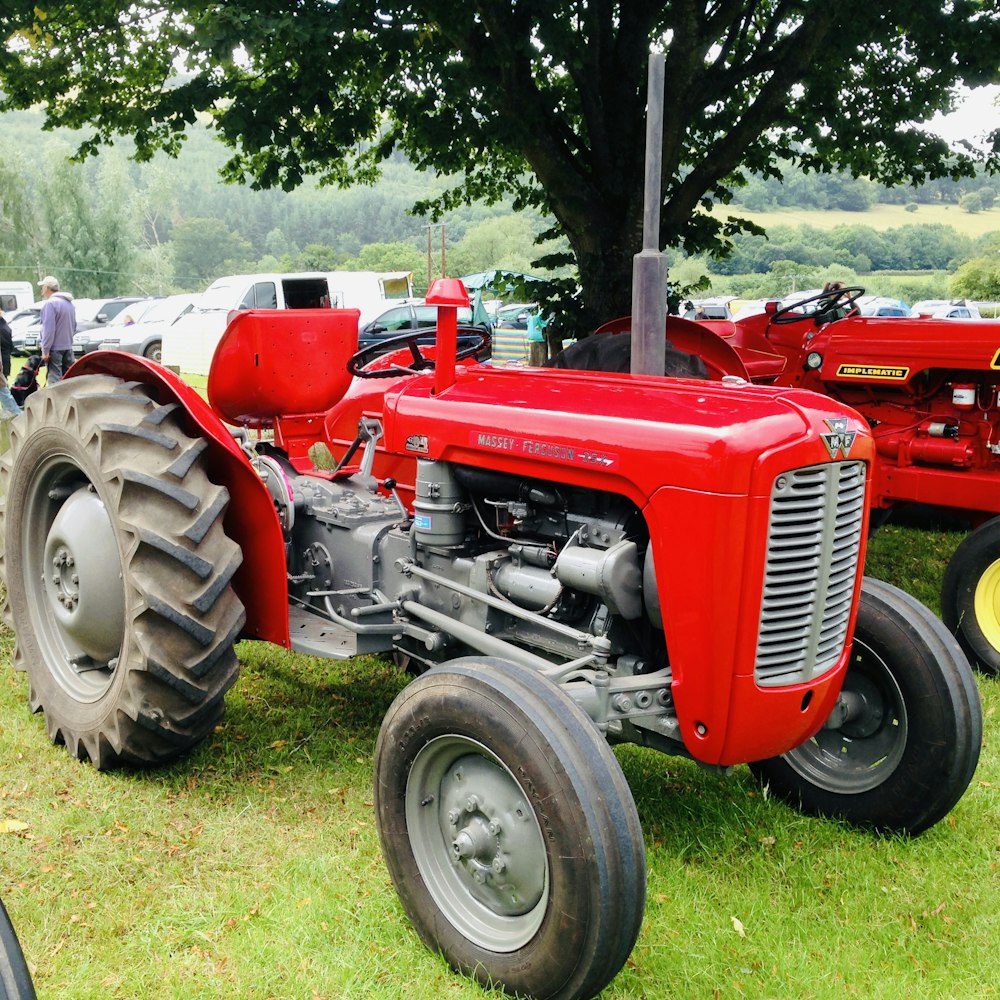 red tractor on green grass field during daytime