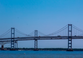 black bridge over blue sea under blue sky during daytime