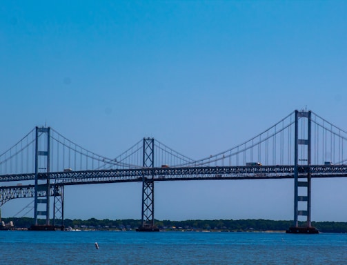 black bridge over blue sea under blue sky during daytime