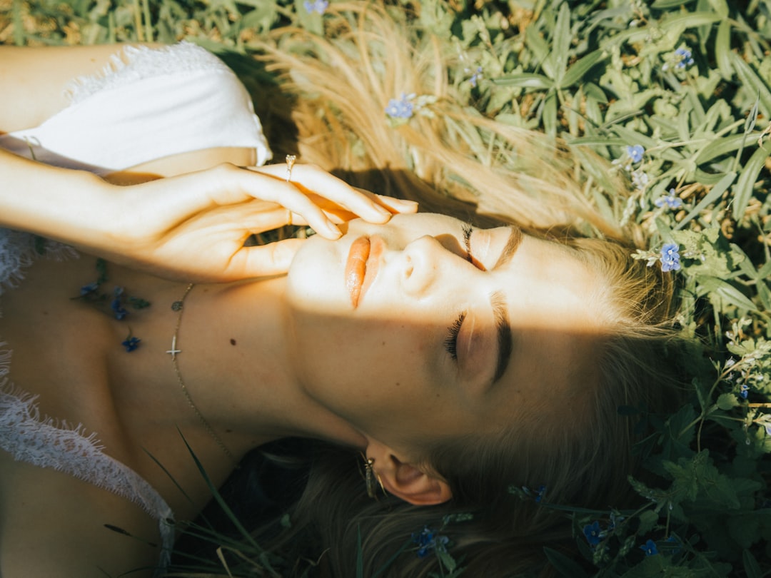 woman lying on green grass