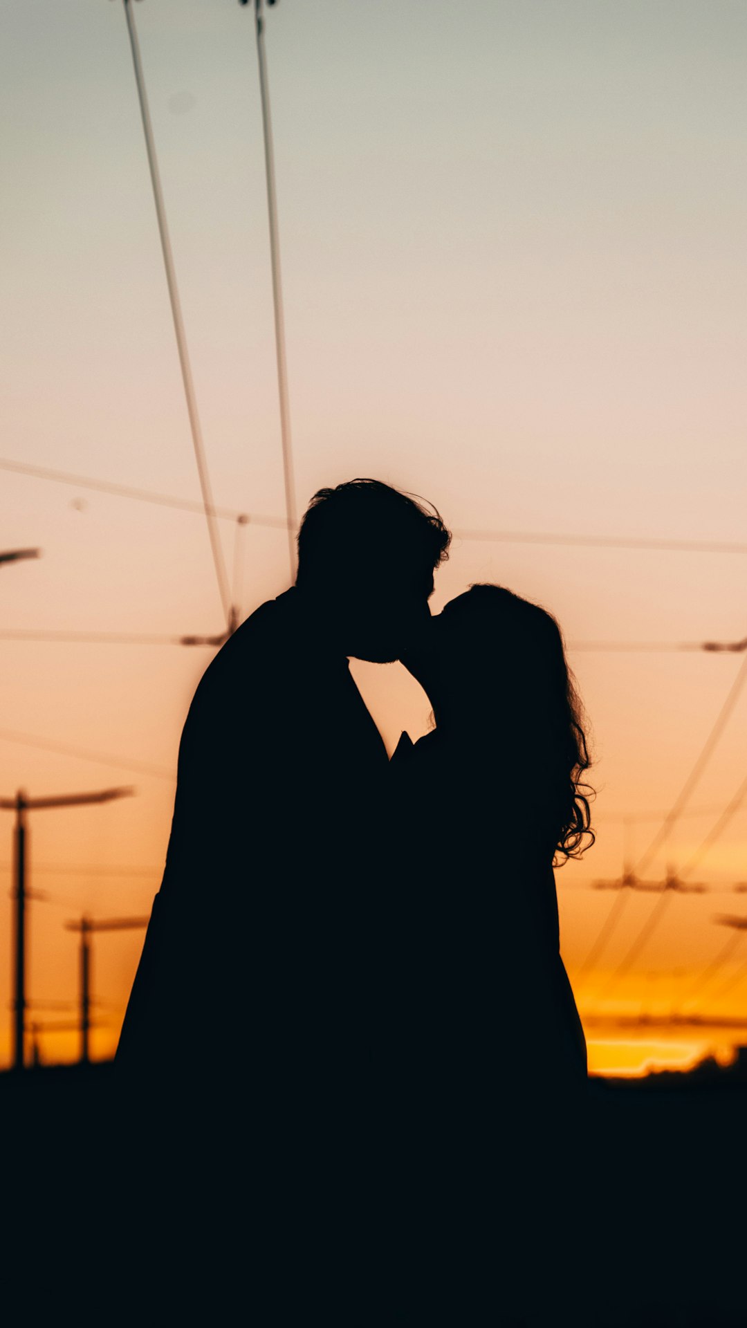silhouette of man and woman kissing during daytime