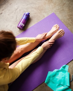 woman in yellow pants lying on purple textile