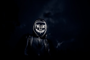 grayscale photo of man in black leather jacket wearing black and white helmet