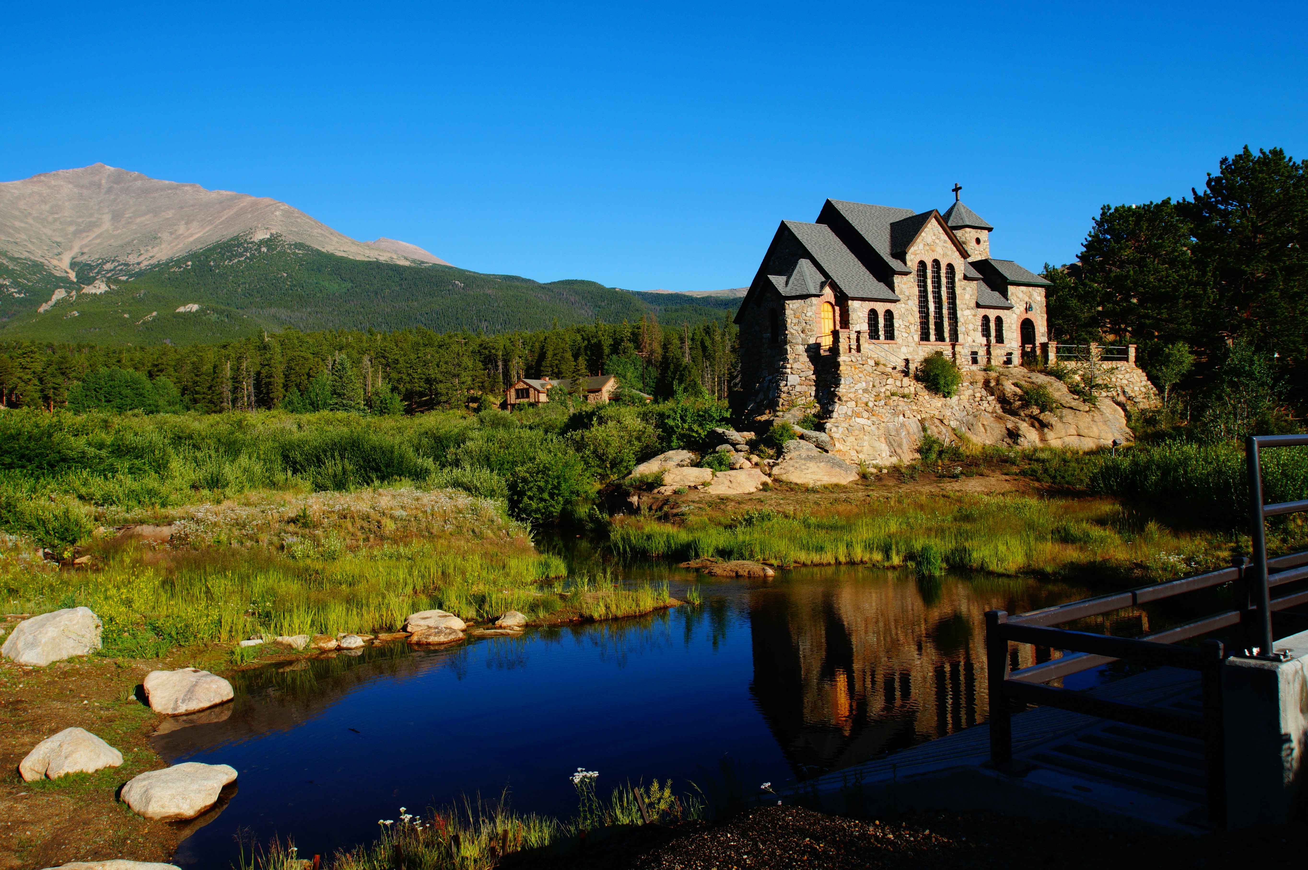 Weißes und braunes Betonhaus in der Nähe des Sees unter blauem Himmel tagsüber