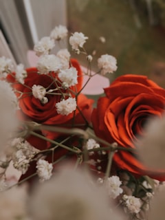 Close-up of elegant white roses intertwined with delicate baby's breath in a bridal bouquet.
