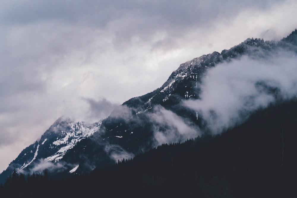 montanha coberta de neve sob céu nublado