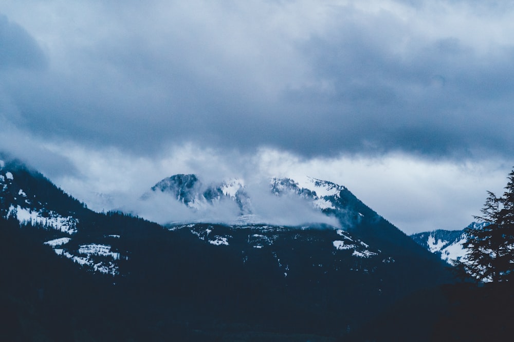 black and white mountain under white clouds