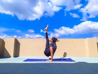 woman in black tank top and black shorts doing yoga on blue yoga mat