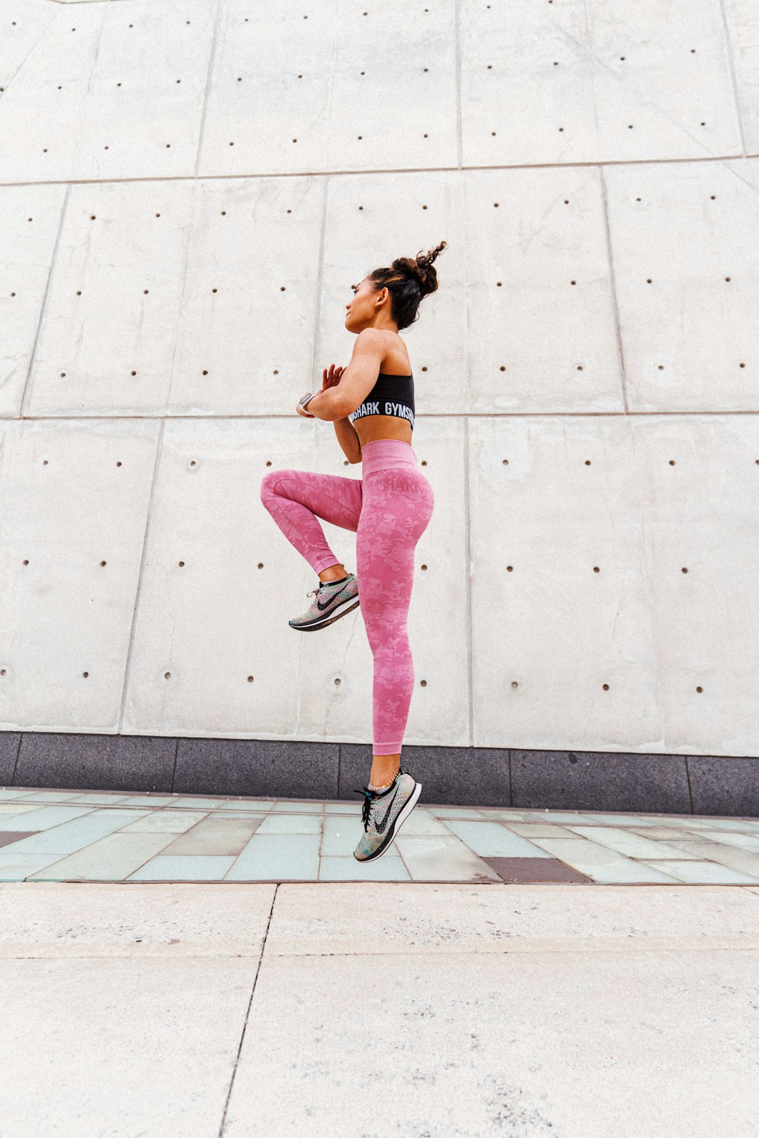 woman in black and white nike sneakers and pink leggings