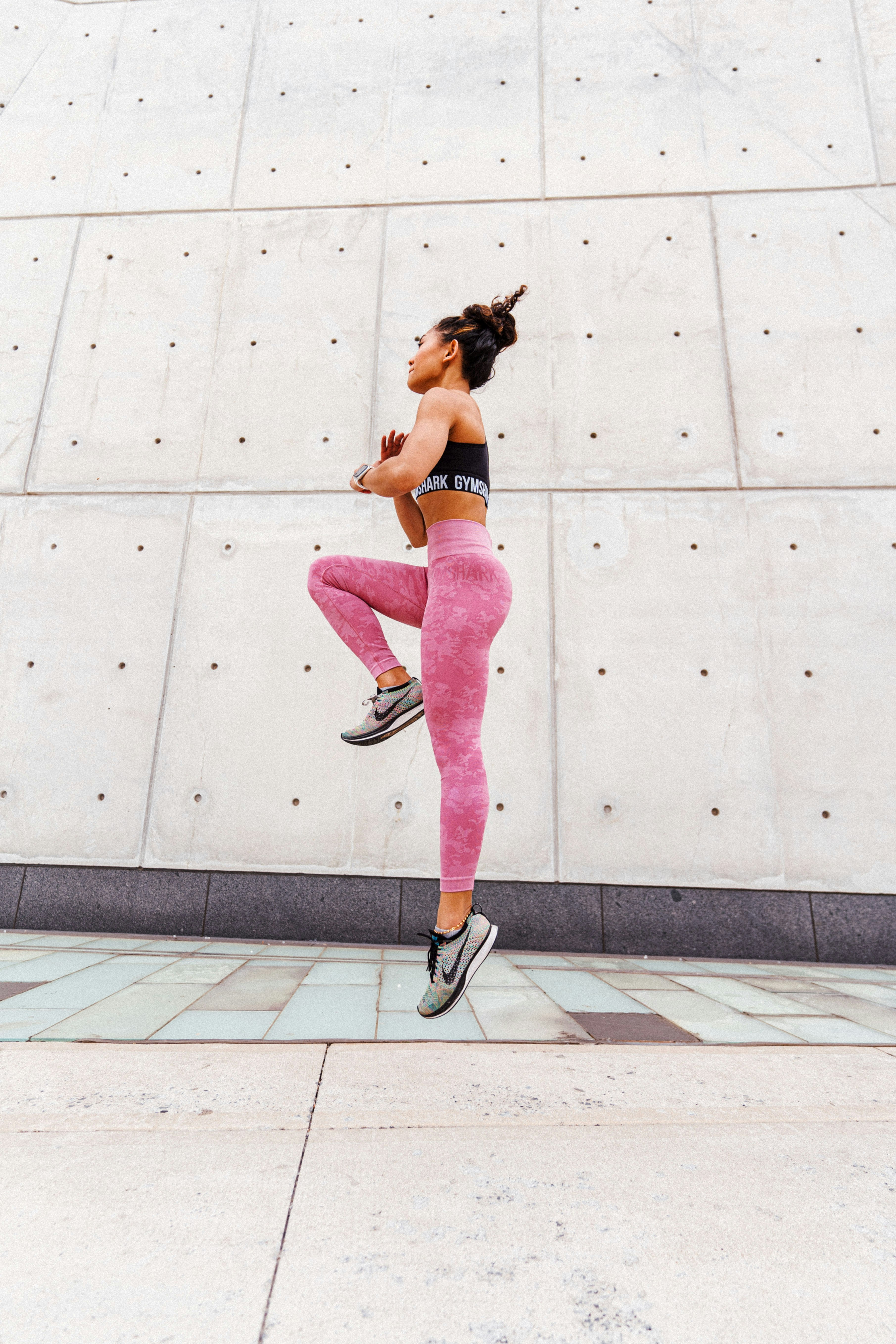 woman in black and white nike sneakers and pink leggings