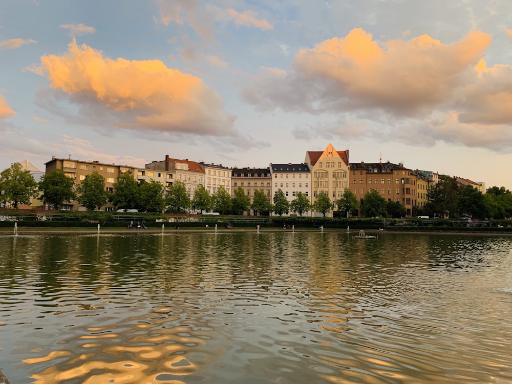 brown concrete building near body of water under cloudy sky during daytime