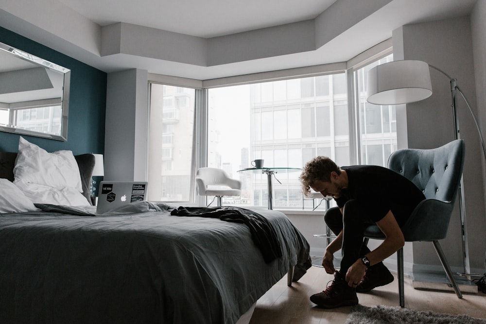 woman in black t-shirt and black pants sitting on bed