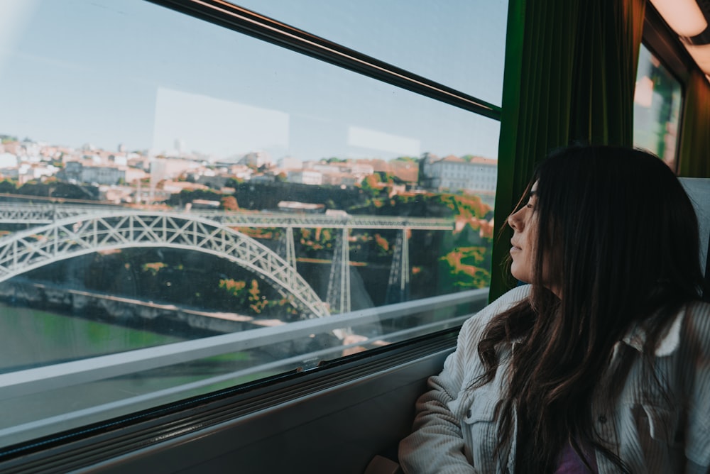 woman in white jacket sitting on window