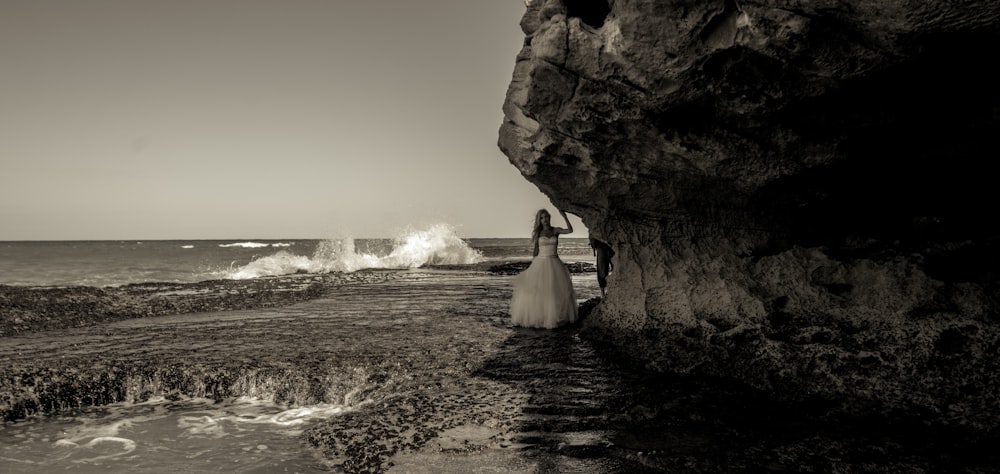 woman in white wedding dress standing on seashore during daytime