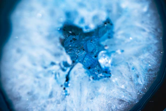 Close-up of a shimmering resin geode with vibrant blue and gold hues catching the light.