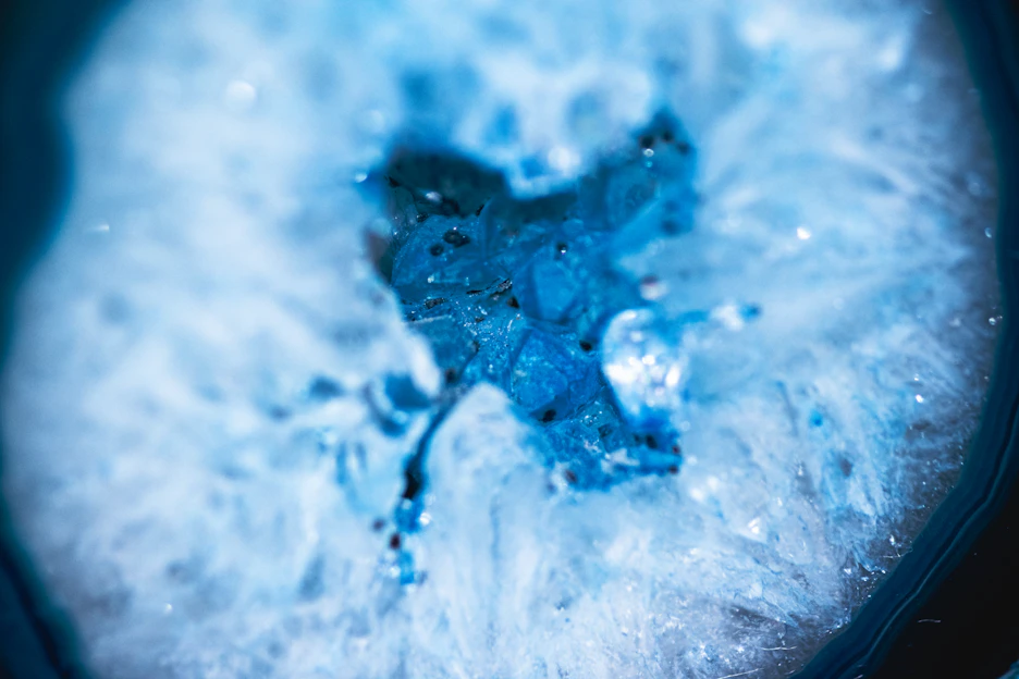 Close-up of a shimmering resin geode with vibrant blue and gold hues catching the light.