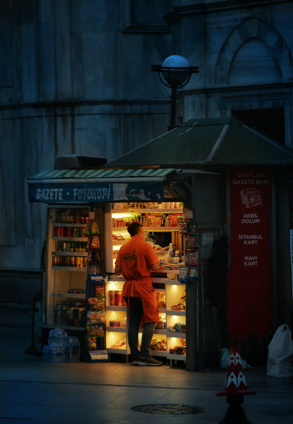 man in red t-shirt standing near store