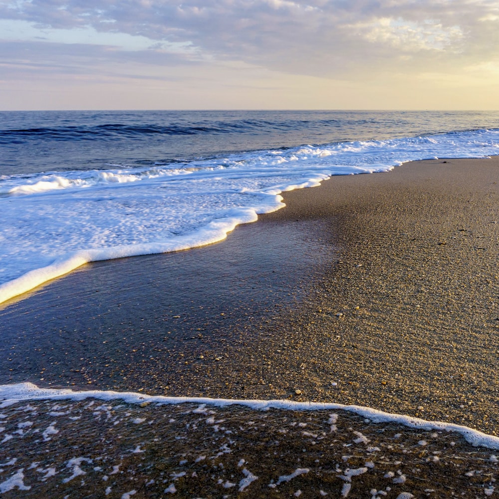 sea waves crashing on shore during daytime