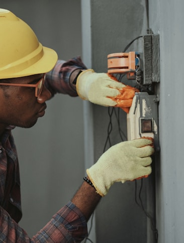 man in brown hat holding black and gray power tool