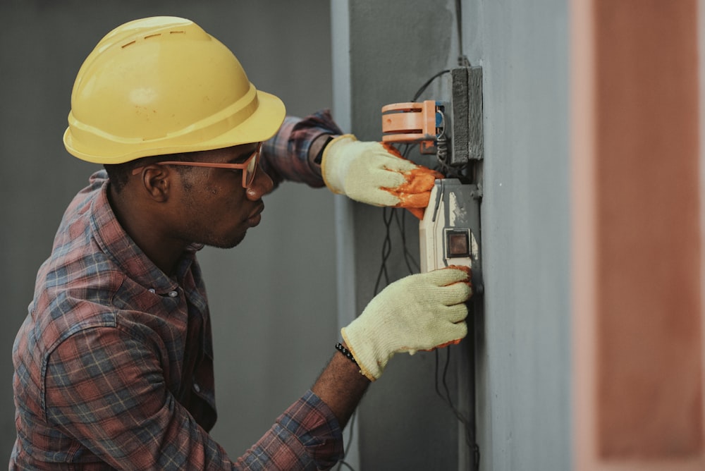 Homme au chapeau brun tenant un outil électrique noir et gris