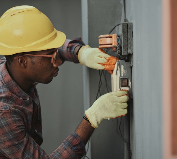 man in brown hat holding black and gray power tool