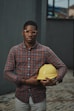 man in blue red and white plaid dress shirt holding yellow plastic bowl