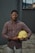 man in blue red and white plaid dress shirt holding yellow plastic bowl
