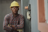 man in blue white and red plaid button up shirt wearing yellow hard hat holding black