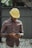 man in red blue and white plaid dress shirt wearing yellow hat holding black smartphone