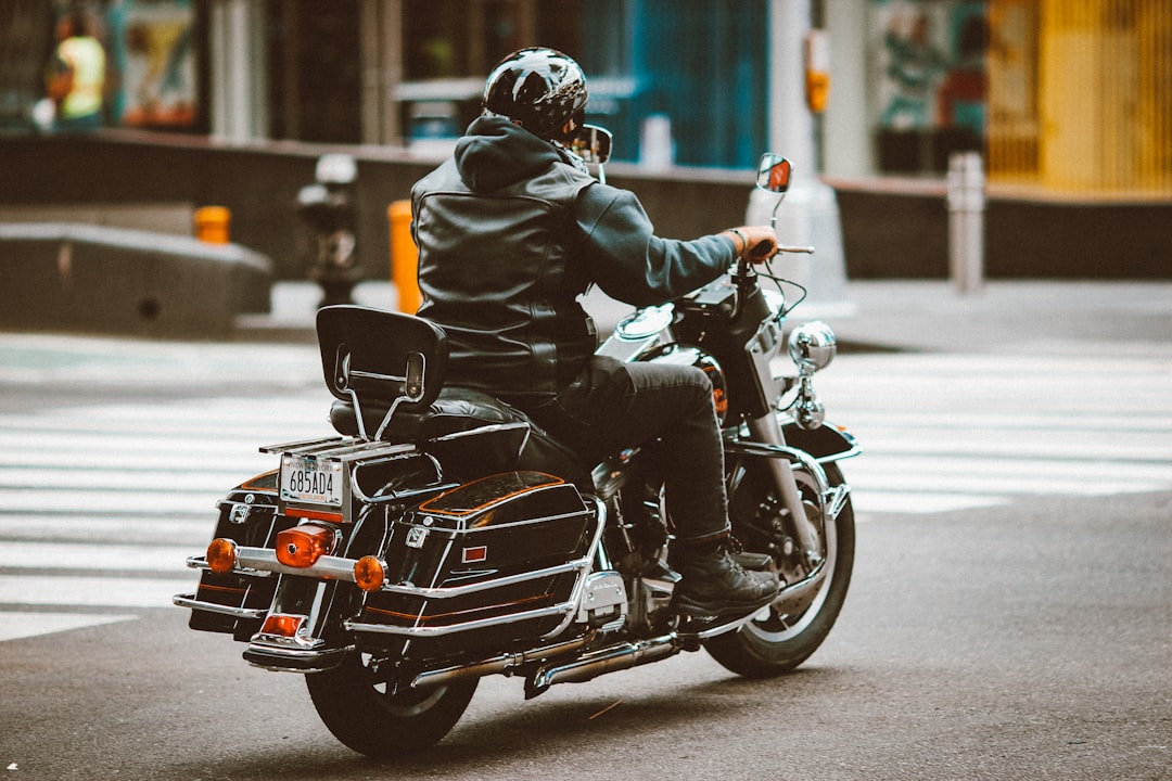 man in black leather jacket riding black motorcycle during daytime