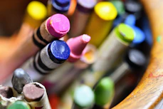 A close-up of colorful crayons and drawings made by children