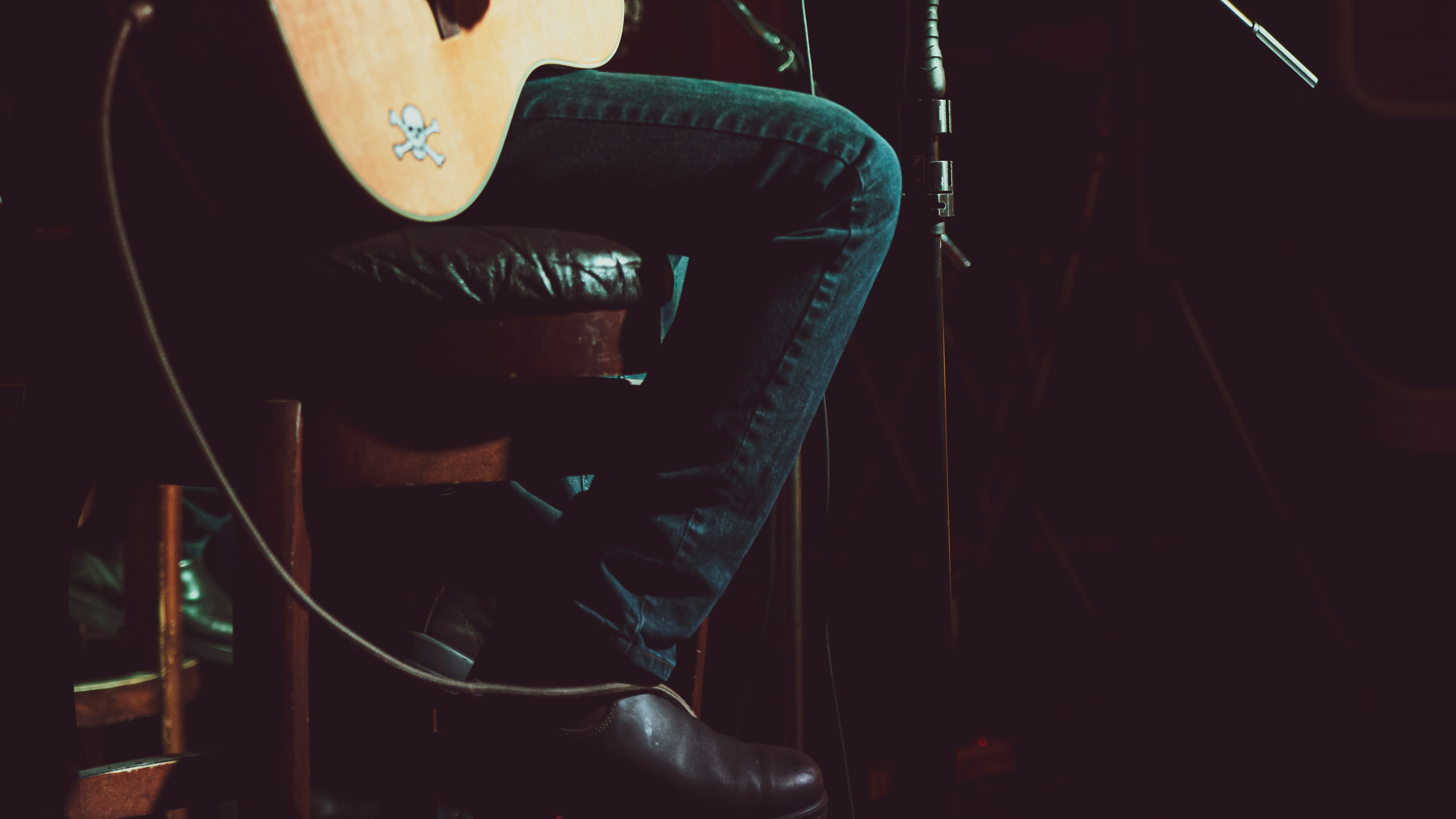 man in black leather jacket and black pants sitting on black leather chair