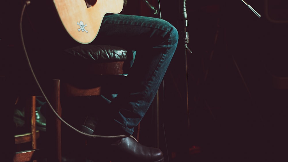 man in black leather jacket and black pants sitting on black leather chair