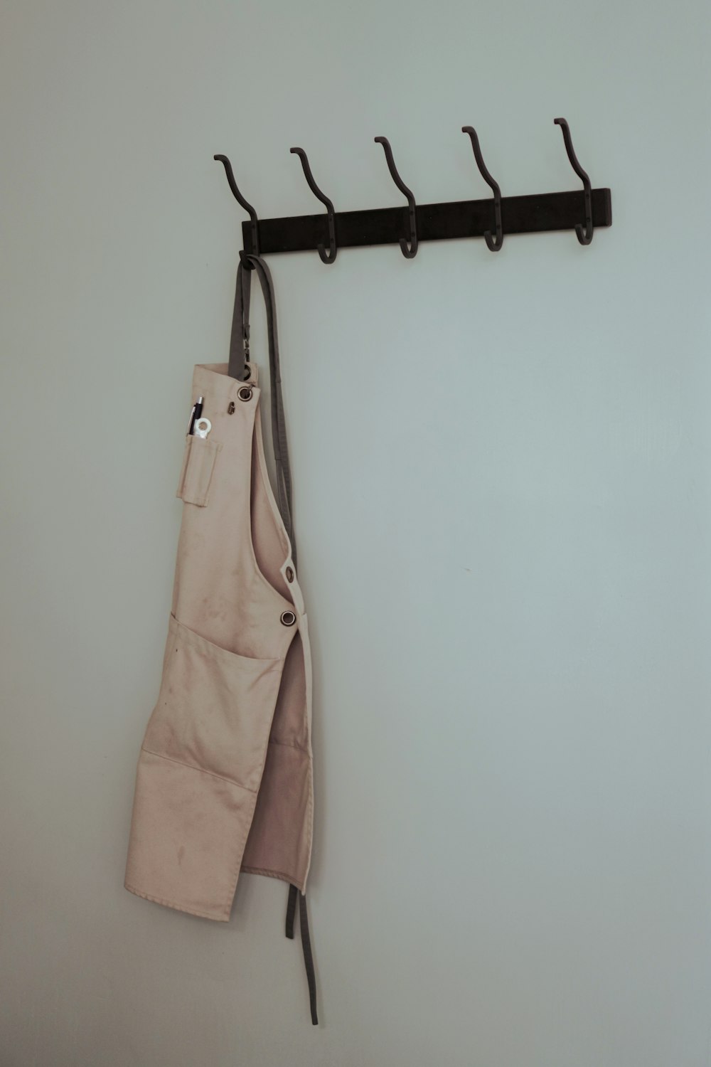 brown leather sling bag hanged on black clothes hanger