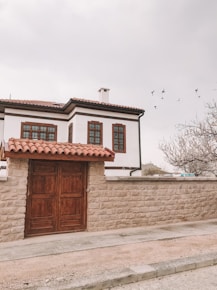 brown wooden door on white concrete building