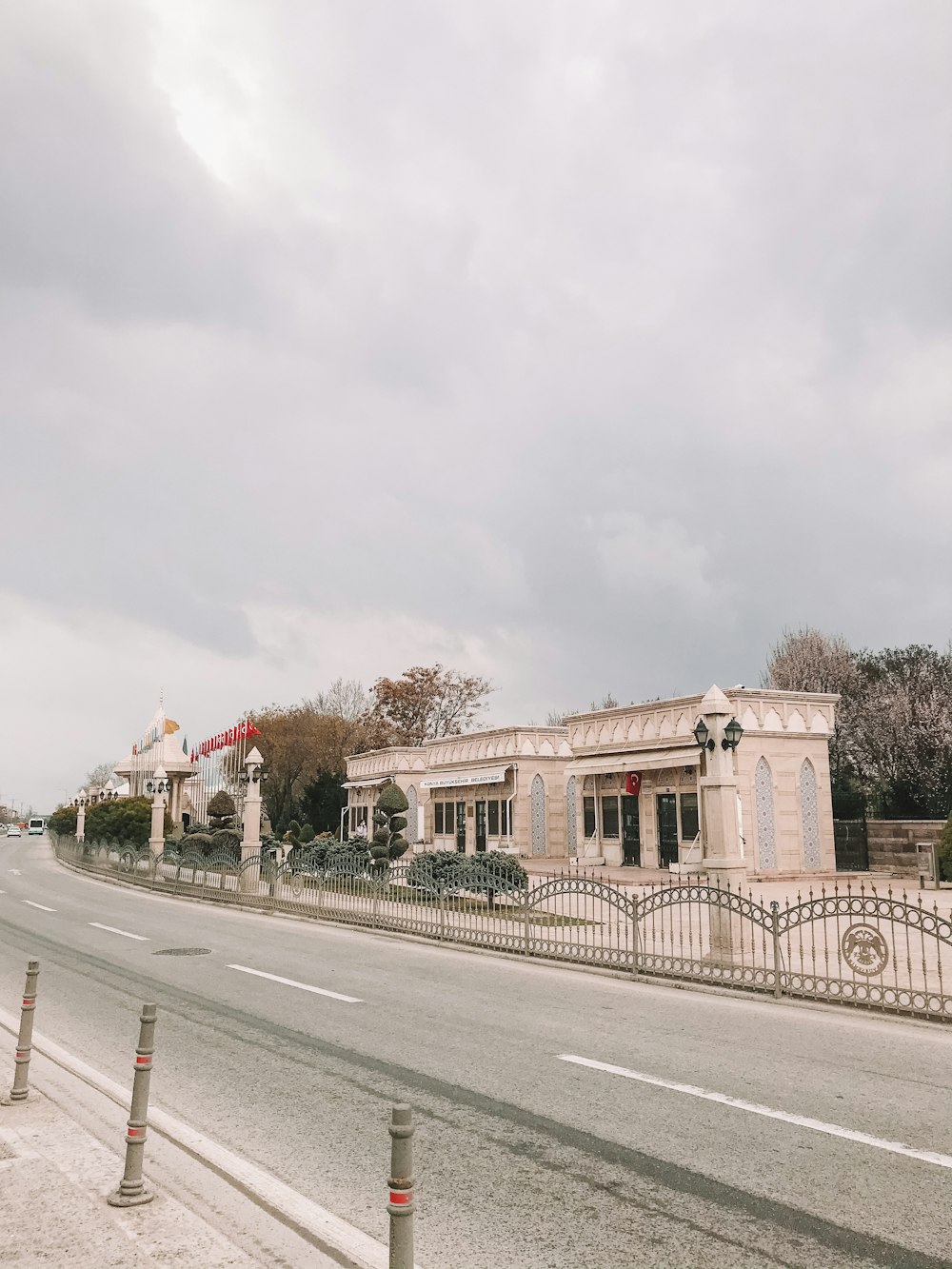 white concrete building near road under white clouds during daytime