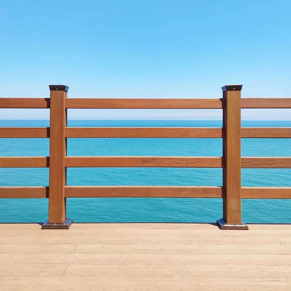 brown wooden fence on brown sand during daytime