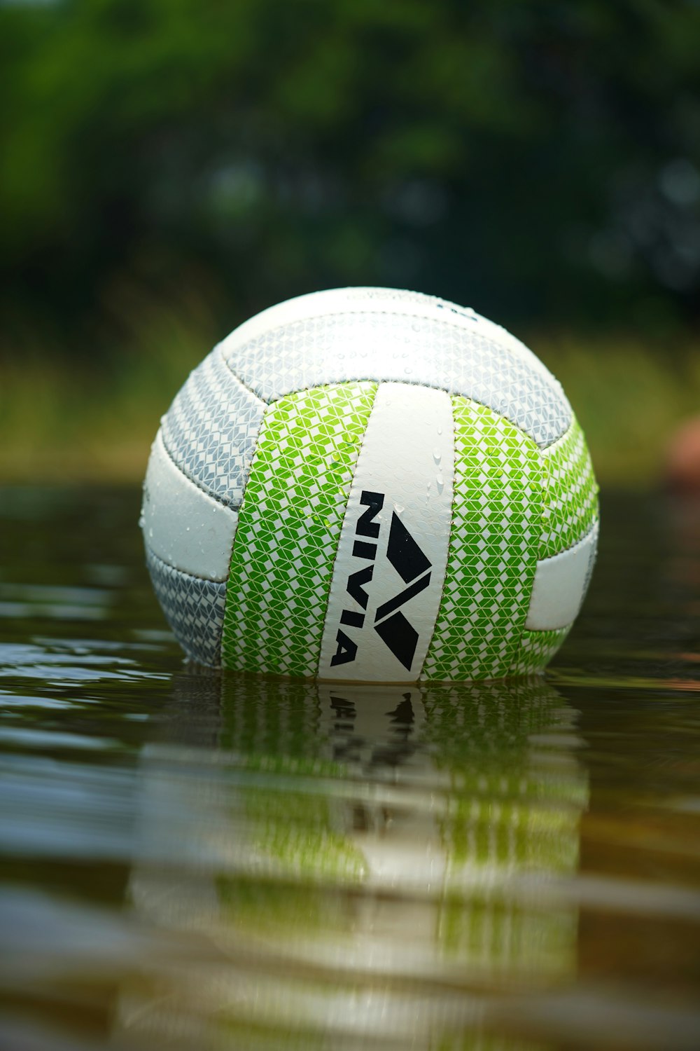 Balón de fútbol blanco y verde en el agua