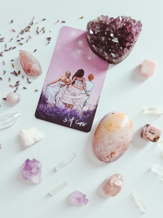A tarot reading card surrounded by crystals