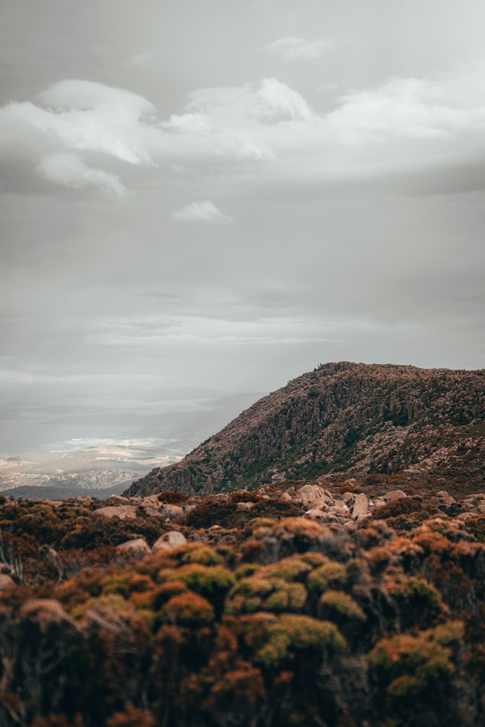 Brauner und grüner Berg unter weißen Wolken